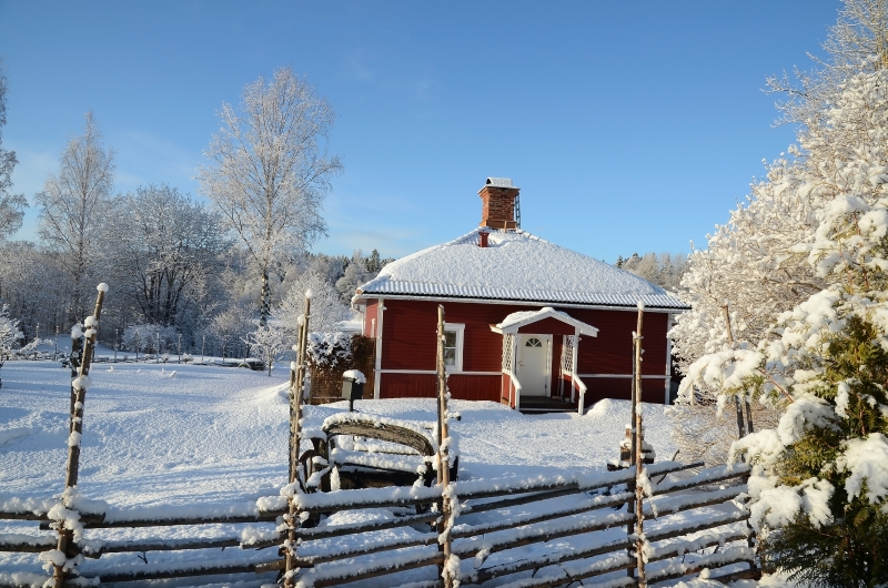 Röd stuga i snön